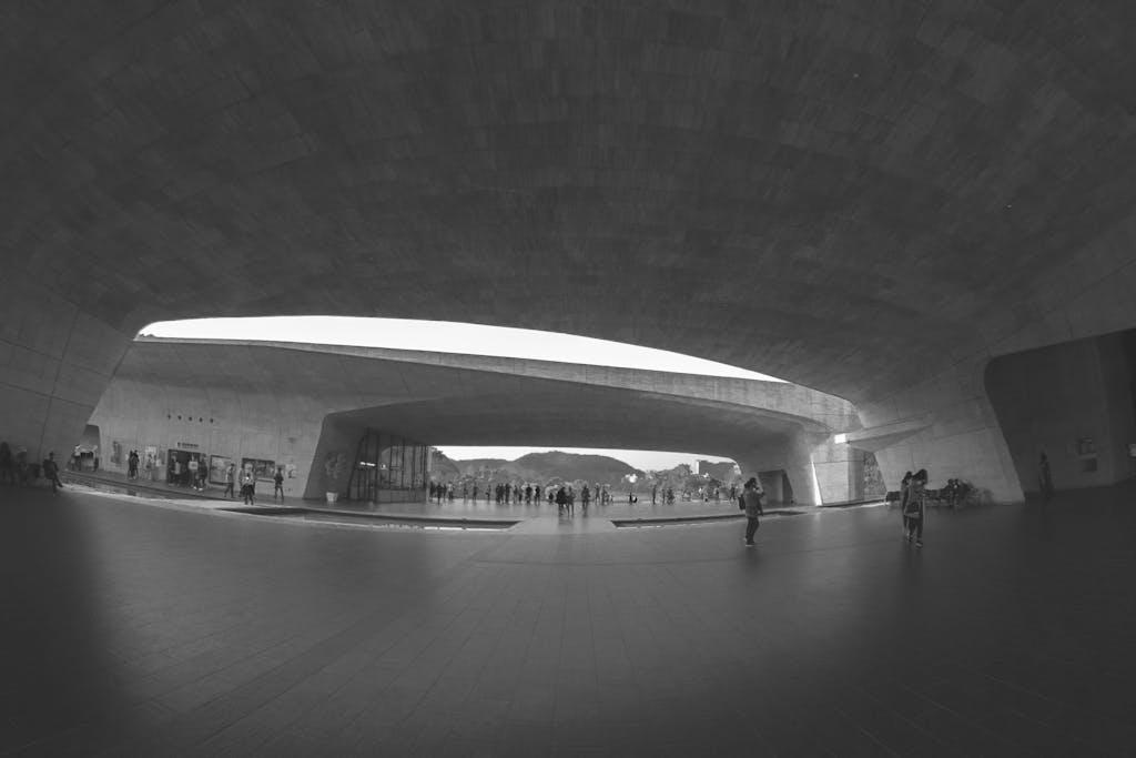 A black and white tunnel scene showcasing modern architecture with people walking.