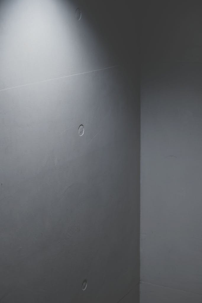 A minimalist concrete wall featuring soft lighting creates an abstract and modern atmosphere.